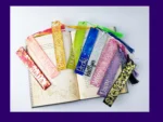 Nine personalised glitter resin bookmarks in assorted colours arranged around an open book, each with a matching tassel