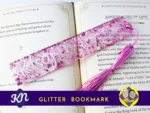 Pink heart-shaped glitter bookmark personalised with the name Kelsey, displayed on an open book with a matching pink tassel.
