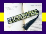 Black glitter bookmark with neon yellow and silver confetti, personalised with the name Steve and finished with a black tassel.