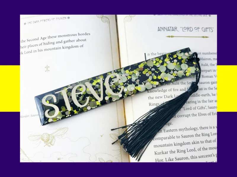 Black glitter bookmark with neon yellow and silver confetti, personalised with the name Steve and finished with a black tassel.