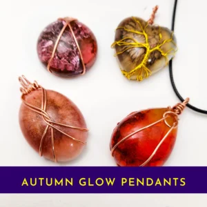 Set of four autumn glow resin pendants with copper wire wrapping in red, amber, pink and earthy tones – handmade jewellery collection