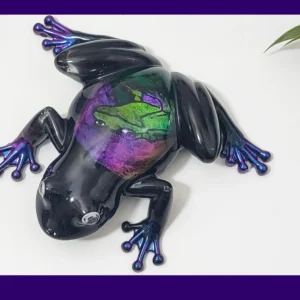 Enchanted Prism Frog resin ornament shown from above, with purple lettering on a banner across the image.