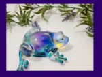 KC-FG-AUR-01 Aurora-shimmer resin frog displayed with green leaves and lavender accents.