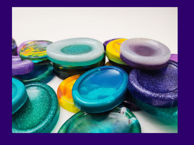 SOLO-RND01_Hero Close-up of several handmade resin calming stones stacked in a row, showing the variety available in the Chaos Solo lucky dip.