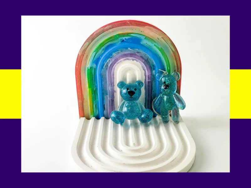Blue resin Worry Bear handheld and keyring pair displayed on white rainbow arch tray – anxiety calming bears