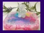 2. Kirnix Listing Primary Close-up of a clear glitter teddy sitting on the lid of a pastel rainbow resin treasure box with iridescent sparkle flakes.