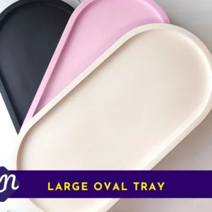 Three large oval eco-resin trays stacked (black, pink and white) on a white background, used as the primary product image for the Large Oval Tray.