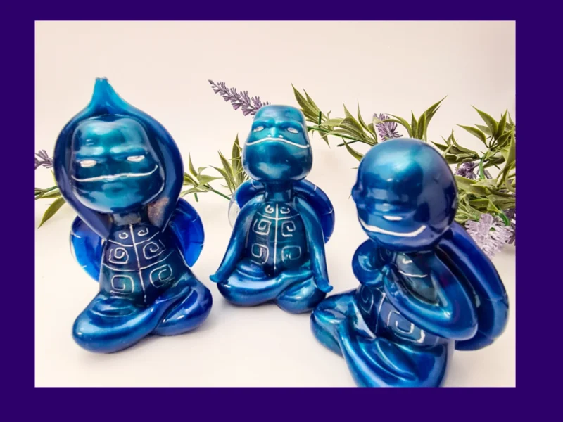 “OOAK blue Zen turtle trio displayed together in outdoor-style foliage background, showing metallic resin shine.”