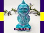 “Front-facing hero shot of the Stretch Pose Aqua Zen Turtle, featuring its raised arms, teal and purple swirl resin and decorative shell.”