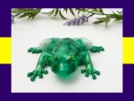 KC-FG-EMRFROG-OOAK015. Kirnix Listing “OOAK green crackle resin frog photographed from an angled front view with lavender sprigs.”