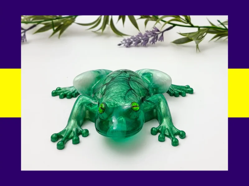 “OOAK green crackle resin frog photographed from an angled front view with lavender sprigs.”