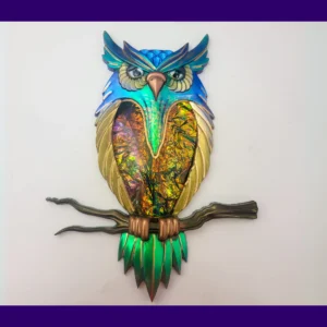 Full view of “The Starlit Sentinel” owl décor on a white background, featuring blue-green shimmer, gold wings, rainbow foil chest, and a bronze branch.