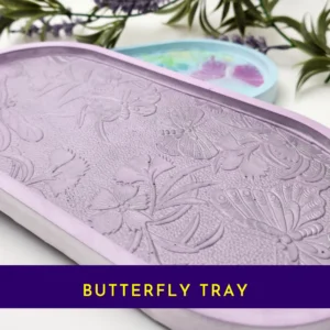 “Front view of pastel resin trinket tray featuring raised dragonflies, butterflies and floral details.”