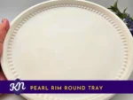 KC-TRAY-PEARL-RND-00102_Primary-Listing-Image Primary-Listing-Image.webp: White Pearl Rim Round Tray with beaded rim, held in hand with greenery in the background; product title banner on the image.
