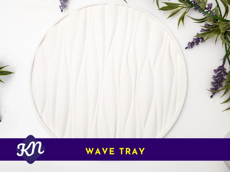 White round wave-textured tray on a white background with greenery and lavender, with a purple banner label reading “Wave Tray”.