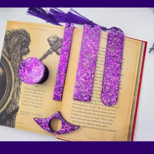 Purple glitter bookmark set laid out on an open book showing all five styles together.