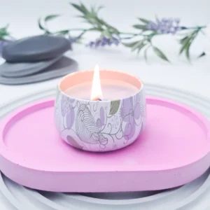 Small oval eco resin tray in soft pink styled with a lit candle on top, modern catchall tray for bedside or coffee table use.