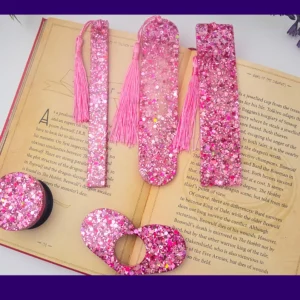 Pink glitter bookmark set laid out on an open book (all five styles visible).
