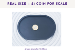 Image 4: Black small oval tray shown from above with a £1 coin for size scale