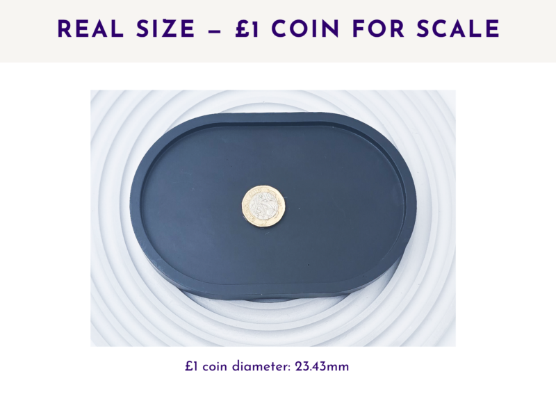 Image 4: Black small oval tray shown from above with a £1 coin for size scale