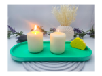 gREEN extra large oval catchall tray styled with two lit pillar candles on a tabletop.