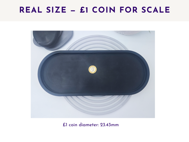 Dark oval tray shown beside a £1 coin for scale.