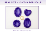 Purple resin worry stones shown beside a £1 coin for size comparison.