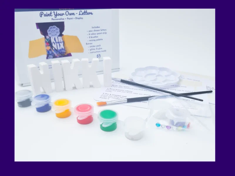 Close up of acrylic paints and brushes included in Paint Your Own Name Kit