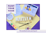 Personalised paint your own name kit showing Kaitlyn name letters with paints, brush, palette and instruction card.