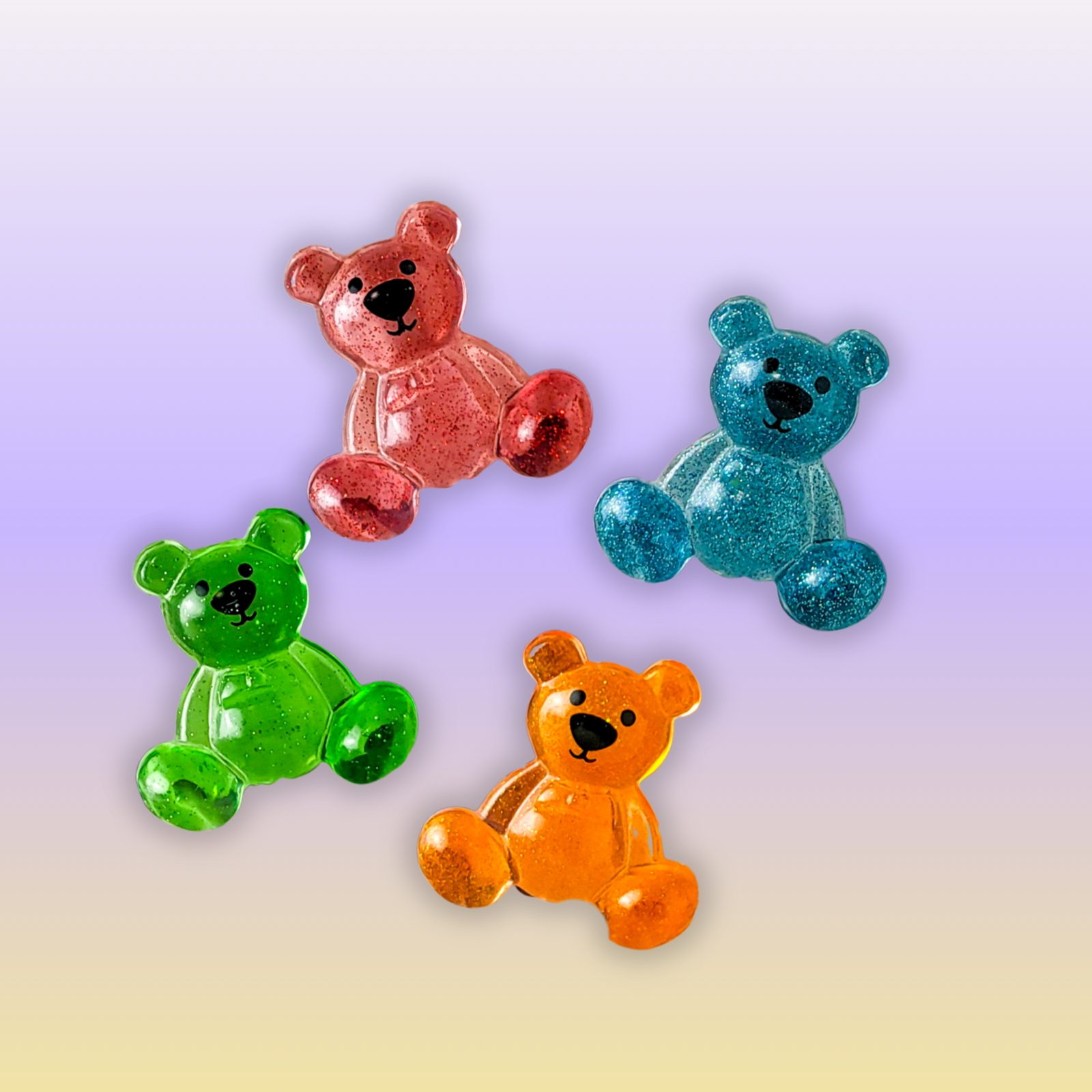 Four glitter resin bear pocket companions in red, teal, green and orange on a warm neutral backdrop.