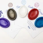 Five oval resin sample stones in purple, black-gold, white, red and blue displayed on branded Kirnix Creations Five Elements Collection cards.