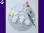 Space craft kit arranged on grey tray with paints brushes glitter and plaster shapes