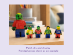 Colorful hand-painted block figures lined up on a wooden table in a classroom setting.