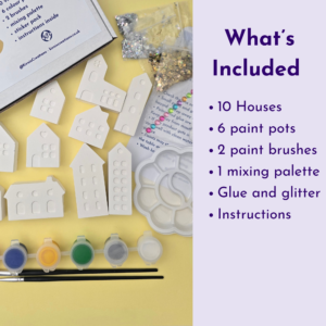 Craft kit contents: white plastic house shapes, small paint pots, brushes, glitter, and glue on a yellow surface with a 'What’s Included' list on lavender background.