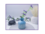 Blue and white marbled decorative bud vase styled with lavender stems on a striped surface with neutral décor