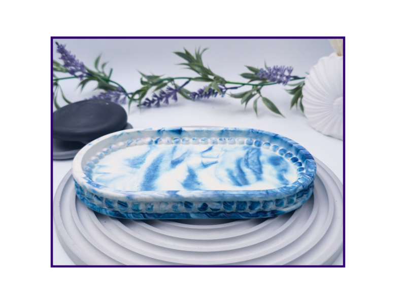 Large blue marble oval catchall tray shown empty on a pale ribbed surface.