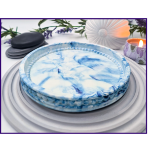 Clean angled view of a blue and white marbled oval tray on a ribbed grey mat