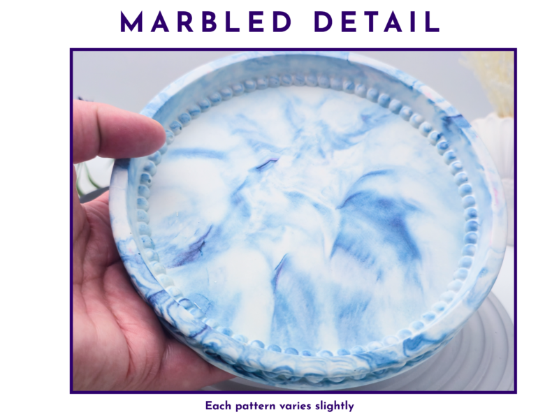 Close-up of the blue and white marbled detail on the oval tray held in hand