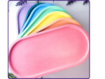 Stack of oval trays in multiple colours fanned out together