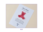 Tilted white card on a beige background featuring a red glittery bear and the title 'Brave Bear'