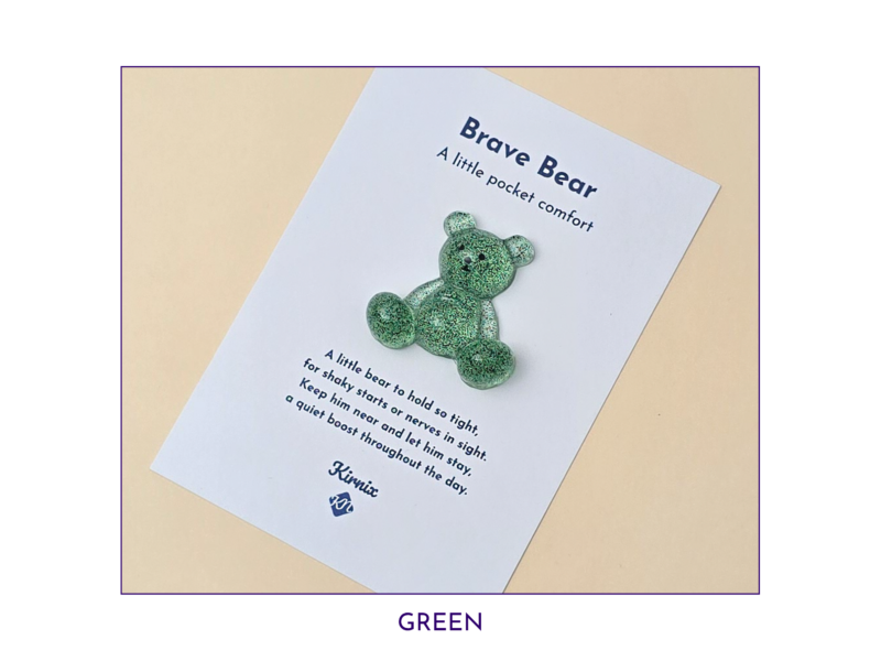White product card titled 'Brave Bear' with a green glitter bear attached, on a pale background; reads 'A little pocket comfort' and includes a short poem.