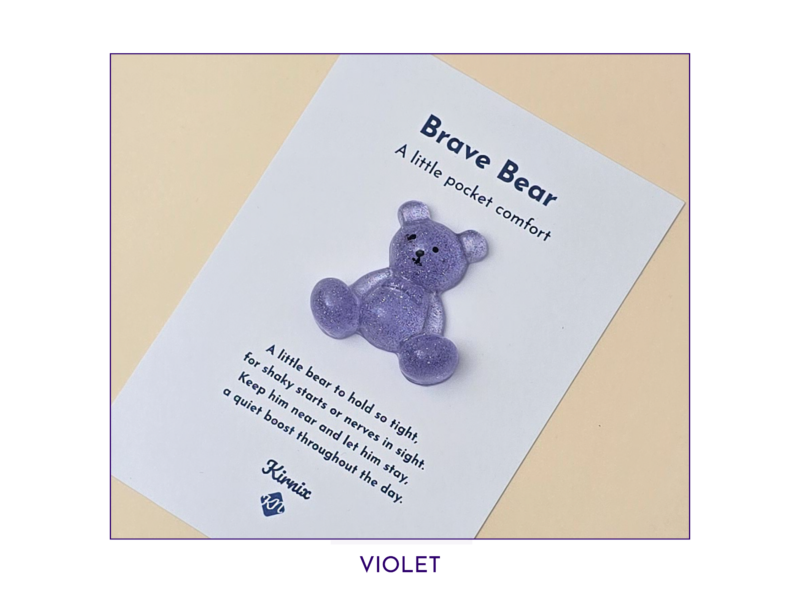 Purple glittery teddy bear on a white card that reads 'Brave Bear' and 'A little pocket comfort'—a comforting keepsake image.