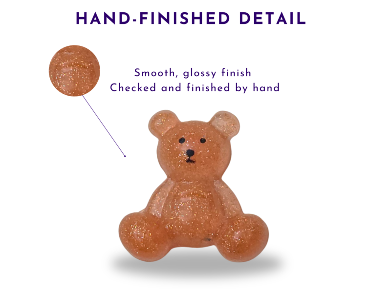Close-up of the Steady Bear glitter finish in warm orange, showing the smooth glossy surface and hand-finished detail.