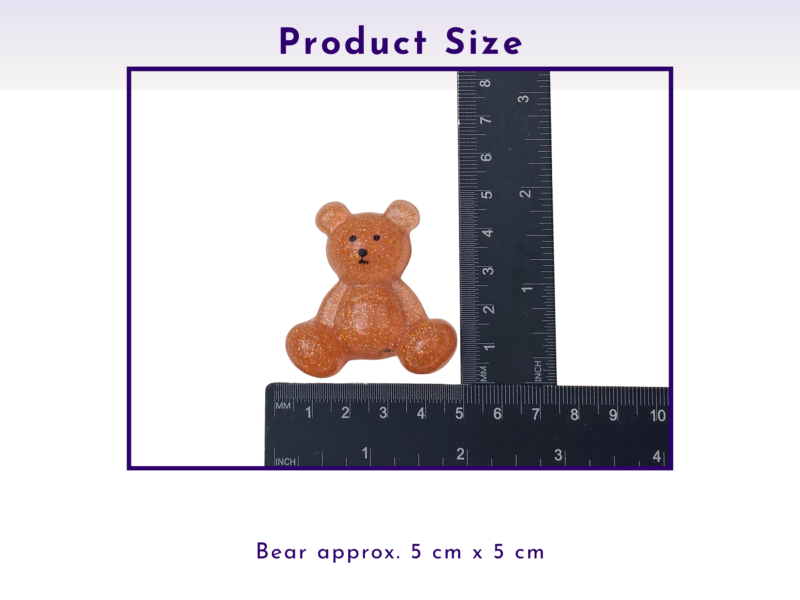 Small glittery orange bear figurine beside a ruler, indicating about 5 cm square size.