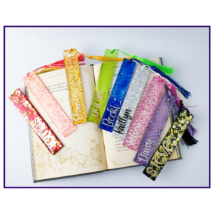 Colorful glittery bookmarks with tassels laid across an open book.