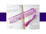 KXK-RBMK-15 Open book with ornate page margins and a pink glitter bookmark laid across the pages.