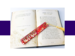 KXK-RBMK-20 Open book with decorative page borders and visible text, a glittery pink confetti bookmark rests diagonally across the pages.