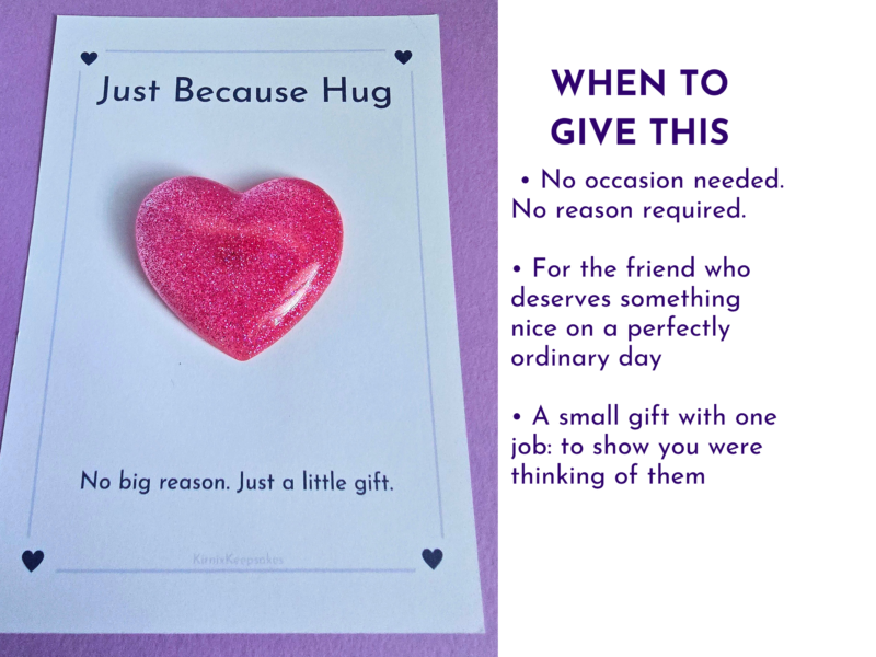 Glittery pink heart on a white card that reads 'Just Because Hug' against a purple background.