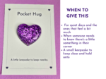 Card labeled Pocket Hug featuring a purple glitter heart on a white backing against a pink background, conveying a keepsake gift for comfort.