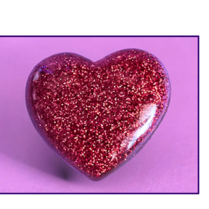 Glittery pink heart against a purple background (valentine theme).